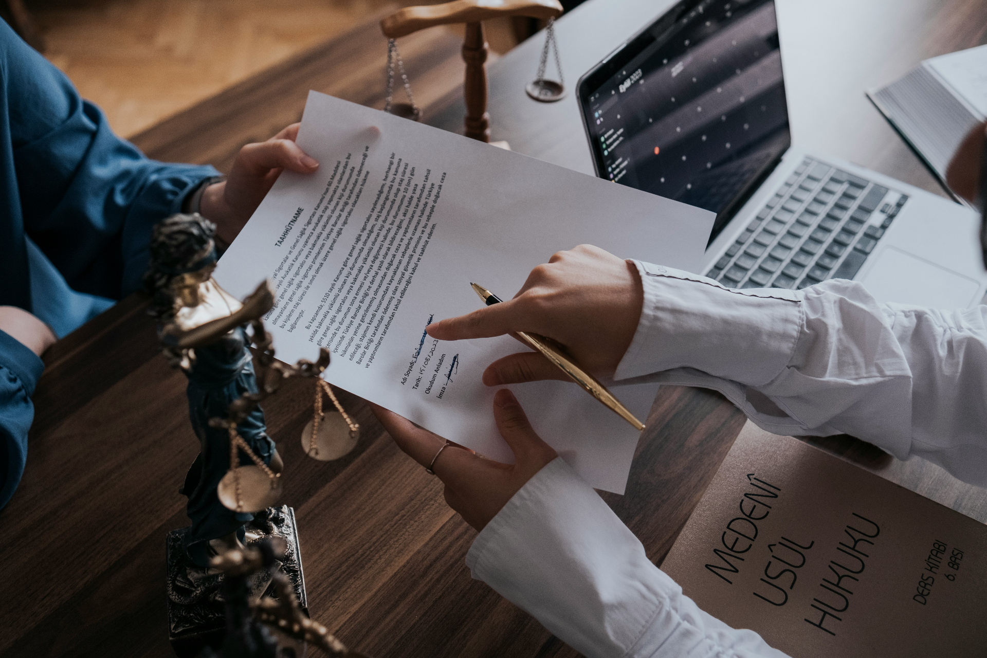 Attorney and client reviewing a signed legal document at a desk with scales of justice, representing EB-5 investor consultation and Q&A