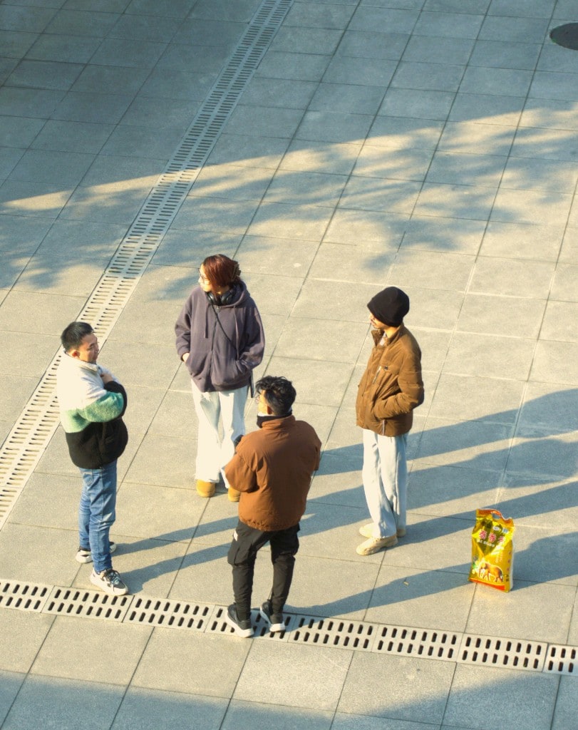 Indian and Chinese STEM OPT students talking on a campus plaza about immigration backup plans