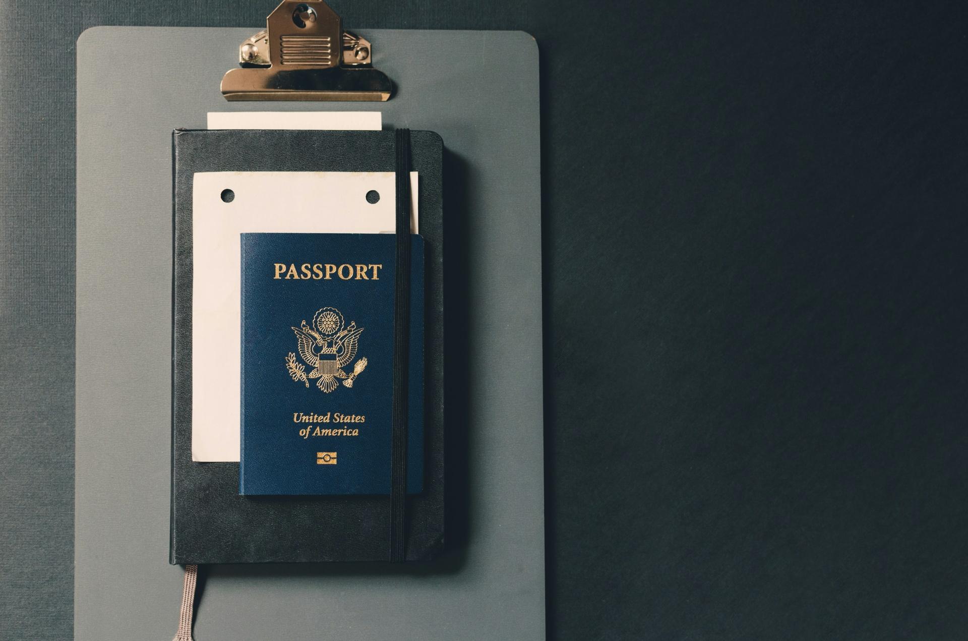 U.S. passport on clipboard representing permanent residency pathways through EB-5 investment